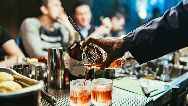 Bar man pouring the drink at a bar.