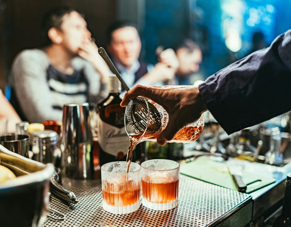 Bar man pouring the drink at a bar.